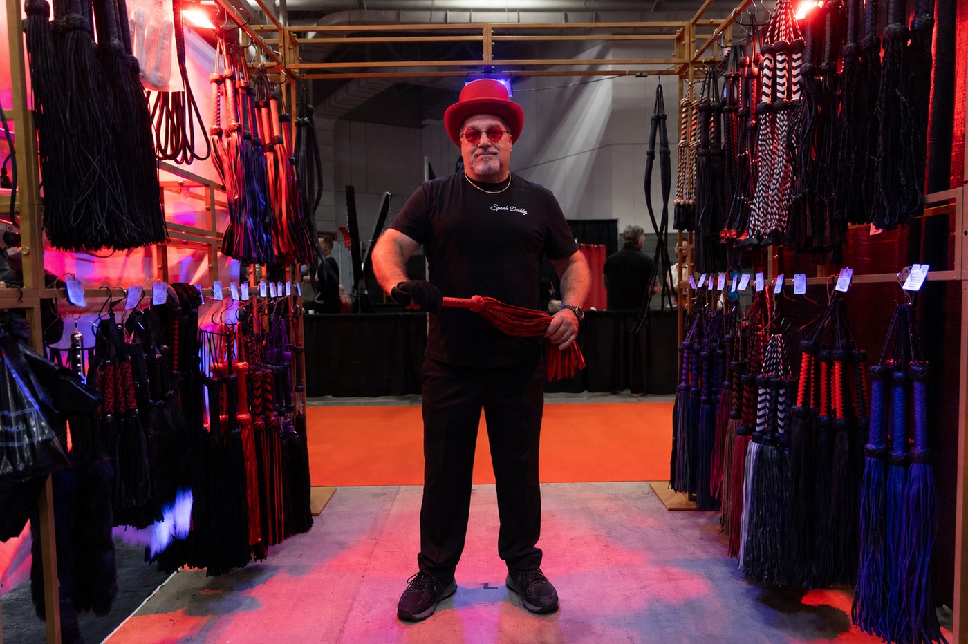 Spank Daddy wearing his red hat and red glasses at a flogger display